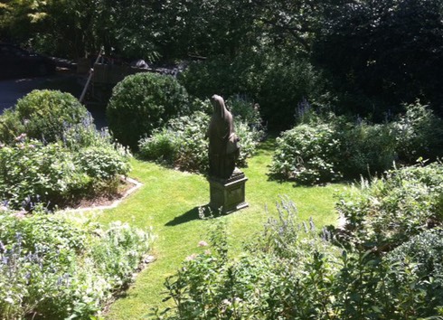 professionally landscaped shrub garden with statue